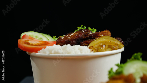 Healthy fresh rice bowl with tomato cuisine and fried chicken wings in dark background