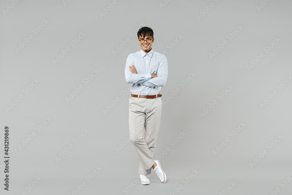 Full length young successful employee business latin man corporate lawyer in classic white shirt glasses hold hands crossed folded isolated on grey color background studio Career achievement concept Full length young successful employee business latin man corporate lawyer in classic white shirt glasses hold hands crossed folded isolated on grey color background studio Career achievement concept