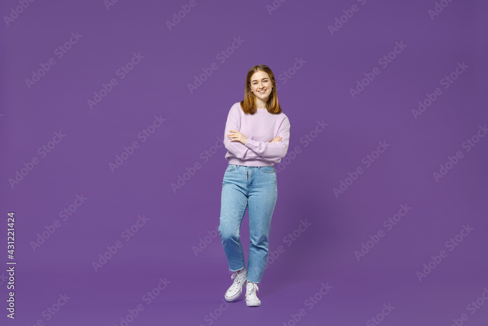 Full length young smiling confident happy student caucasian woman 20s wearing purple knitted sweater hold hands crossed folded isolated on violet background studio portrait People lifestyle concept.