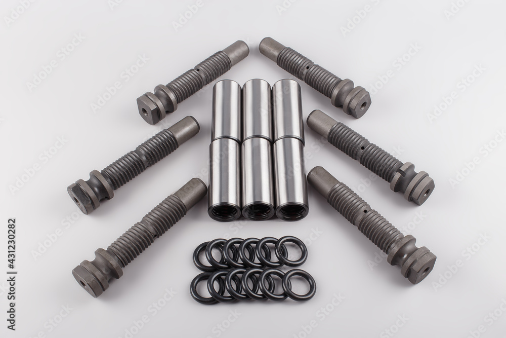 a set of bushing pins and gaskets for car repairs lie on a gray background. Repair kit for the truck. New spare parts for trucks a set of bushing pins and gaskets for car repairs lie on a gray background. Repair kit for the truck. New spare parts for trucks