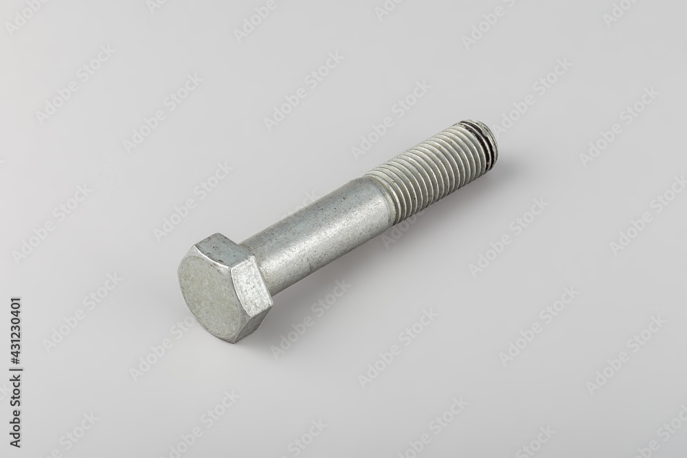 Bolt fastening of the tie spring on a gray background. Truck spare parts mounting bolt. Transmission mounting bolt. Bolt fastening of the tie spring on a gray background. Truck spare parts mounting bolt. Transmission mounting bolt.