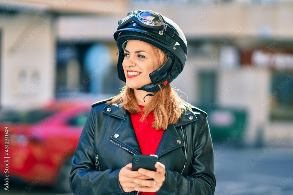 Young latin woman wearing motorcycle helmet using smartphone at the city. Young latin woman wearing motorcycle helmet using smartphone at the city.
