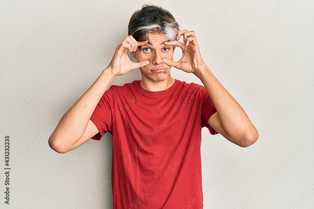 Young hispanic man wearing casual clothes trying to open eyes with fingers, sleepy and tired for morning fatigue Young hispanic man wearing casual clothes trying to open eyes with fingers, sleepy and tired for morning fatigue
