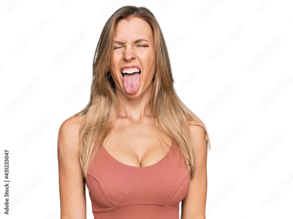 Beautiful caucasian woman wearing casual clothes sticking tongue out happy with funny expression. emotion concept.