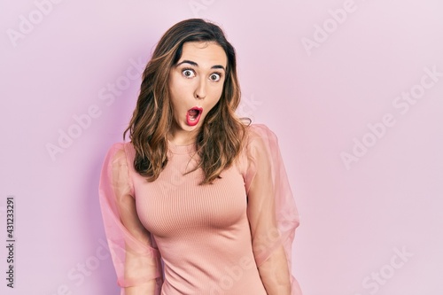 Young hispanic girl wearing casual clothes afraid and shocked with surprise expression, fear and excited face.