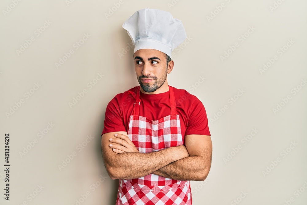 Young hispanic man wearing baker uniform smiling looking to the side and staring away thinking. Young hispanic man wearing baker uniform smiling looking to the side and staring away thinking.