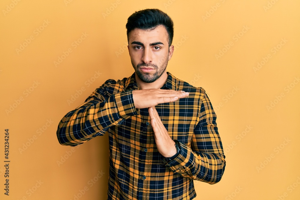 Young hispanic man wearing casual clothes doing time out gesture with hands, frustrated and serious face Young hispanic man wearing casual clothes doing time out gesture with hands, frustrated and serious face