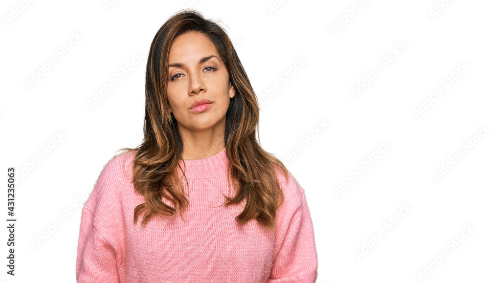 Young hispanic woman wearing casual clothes relaxed with serious expression on face. simple and natural looking at the camera. Young hispanic woman wearing casual clothes relaxed with serious expression on face. simple and natural looking at the camera.