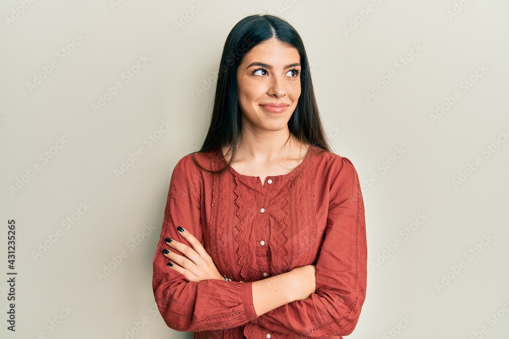 Young hispanic woman wearing casual clothes smiling looking to the side and staring away thinking. Young hispanic woman wearing casual clothes smiling looking to the side and staring away thinking.
