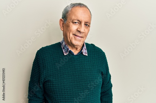 Handsome senior man with grey hair wearing casual sweater with a happy and cool smile on face. lucky person. © Krakenimages.com