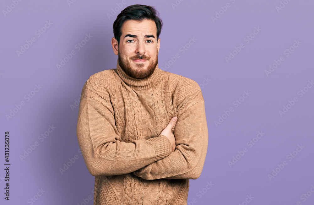 Obraz premium Young hispanic man wearing casual clothes shaking and freezing for winter cold with sad and shock expression on face