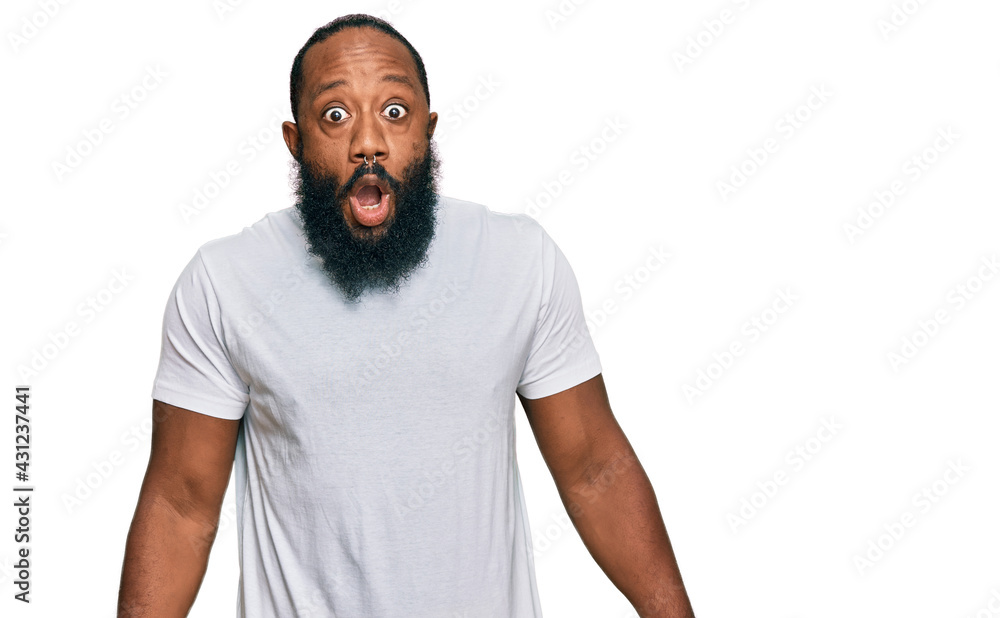 Young african american man wearing casual white tshirt afraid and shocked with surprise expression, fear and excited face. Young african american man wearing casual white tshirt afraid and shocked with surprise expression, fear and excited face.