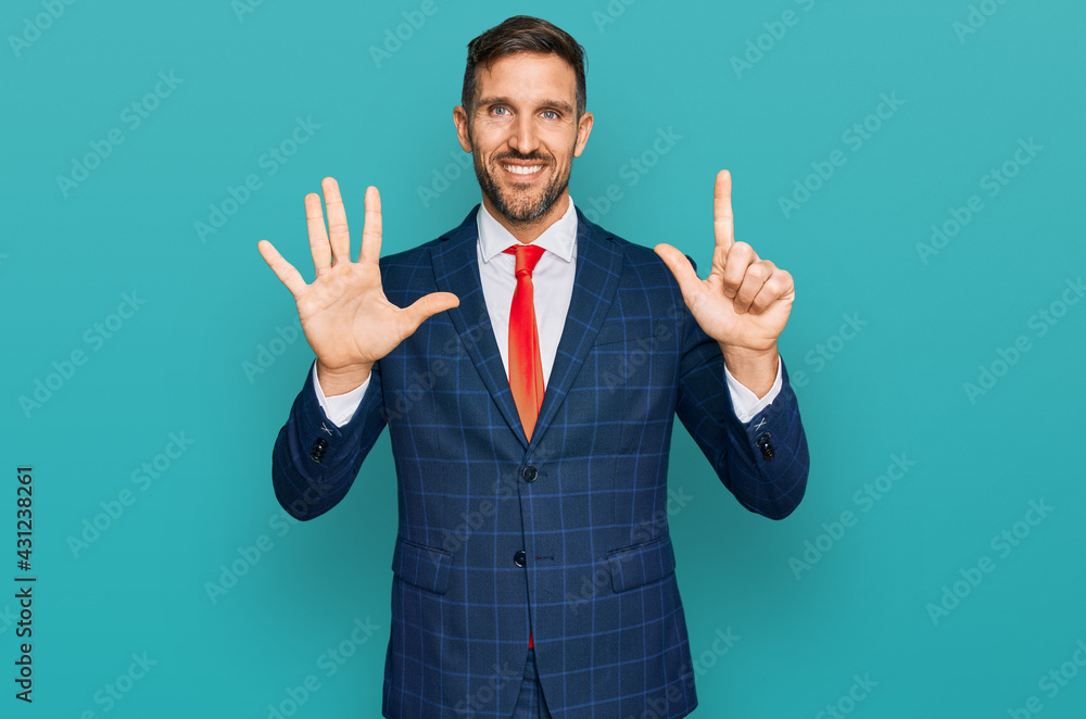 Handsome man with beard wearing business suit and tie showing and pointing up with fingers number seven while smiling confident and happy. Handsome man with beard wearing business suit and tie showing and pointing up with fingers number seven while smiling confident and happy.