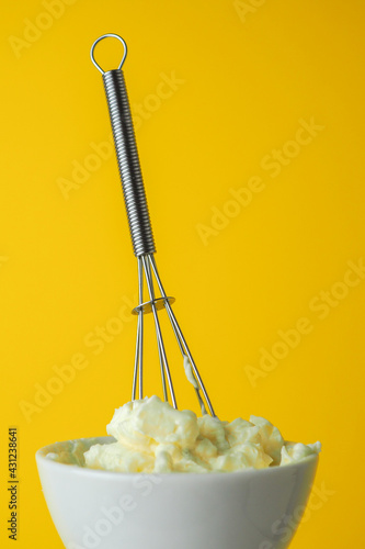 hand held whisk in a bowl of buttercream frosting  photo