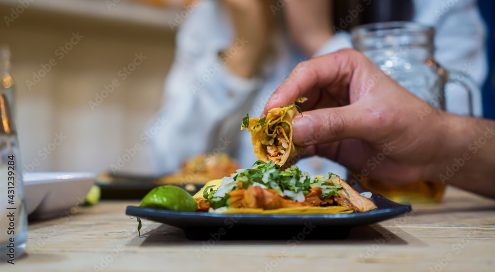 Bitten taco de pastor held by man's hands
