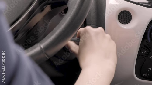 Starting car engine. a woman's hand sliding keys into car switch starting the engine.  Igniting car. The driver inserts the ignition key into the ignition lock, turns it and starts engine