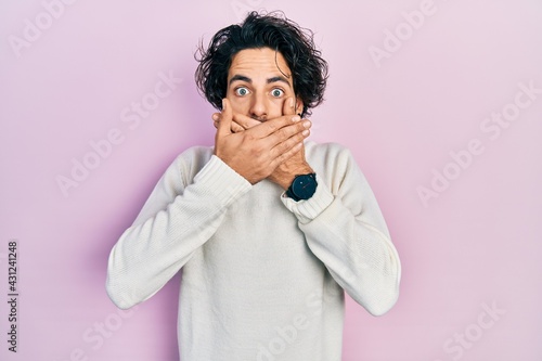 Tableau sur toile Handsome hispanic man wearing casual white sweater shocked covering mouth with hands for mistake