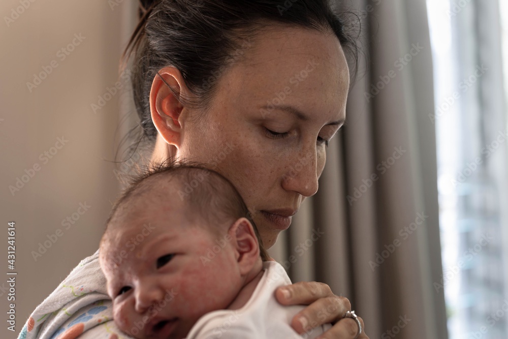 A stressed tired mother trying to put her baby to sleep. Maternity and postpartum. A stressed tired mother trying to put her baby to sleep. Maternity and postpartum.
