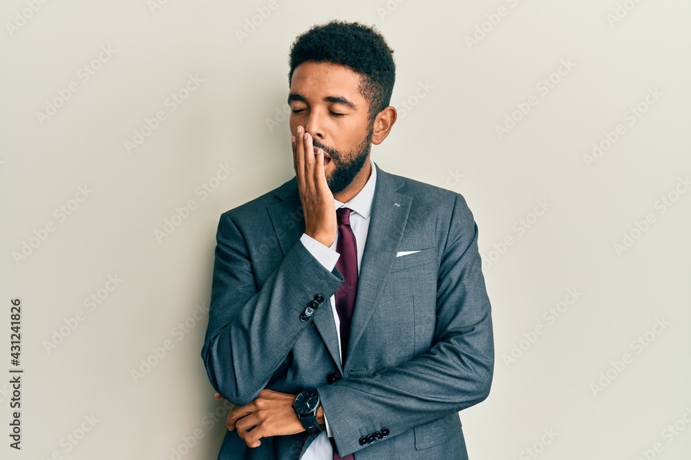 Handsome hispanic man with beard wearing business suit and tie bored yawning tired covering mouth with hand. restless and sleepiness. Handsome hispanic man with beard wearing business suit and tie bored yawning tired covering mouth with hand. restless and sleepiness.
