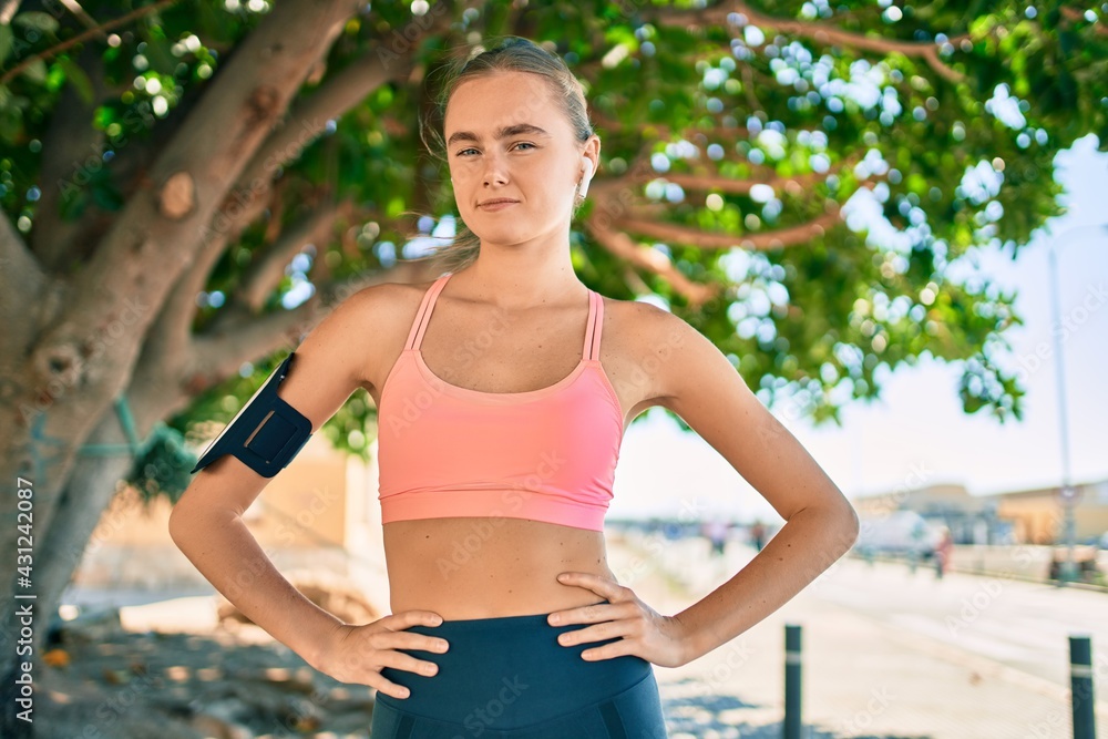 Young blonde sportswoman tired wearing sportswear at the city. Young blonde sportswoman tired wearing sportswear at the city.