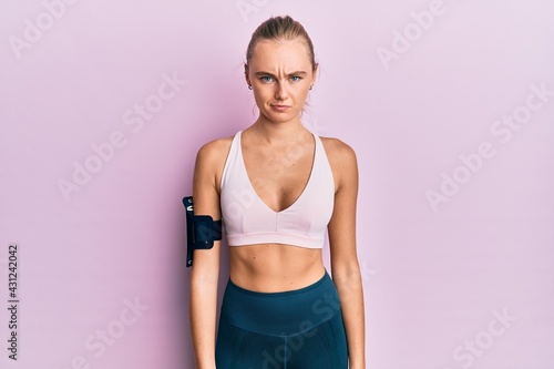 Beautiful blonde woman wearing sportswear and arm band skeptic and nervous, frowning upset because of problem. negative person. © Krakenimages.com