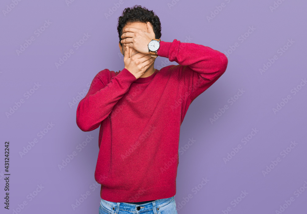 Young handsome man wearing casual clothes covering eyes and mouth with hands, surprised and shocked. hiding emotion Young handsome man wearing casual clothes covering eyes and mouth with hands, surprised and shocked. hiding emotion