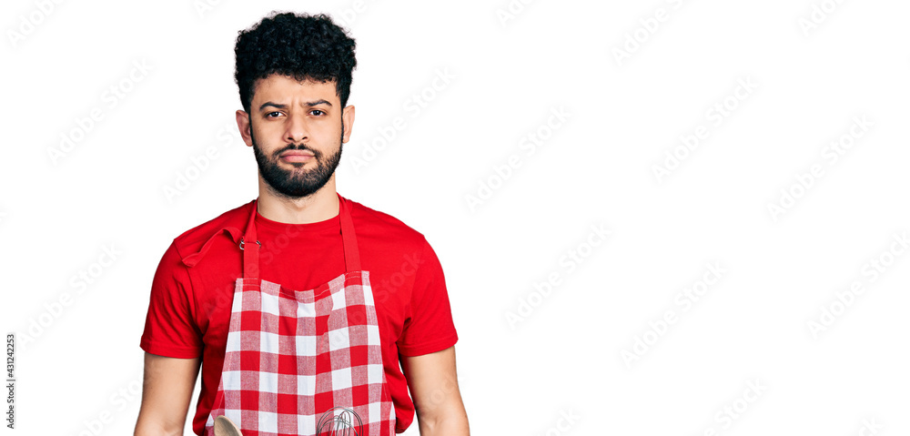 Young arab man with beard wearing cook apron depressed and worry for distress, crying angry and afraid. sad expression. Young arab man with beard wearing cook apron depressed and worry for distress, crying angry and afraid. sad expression.