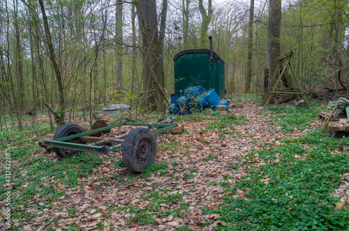 Natural landscape with an old construction site office and a trailer abandoned in the woods.