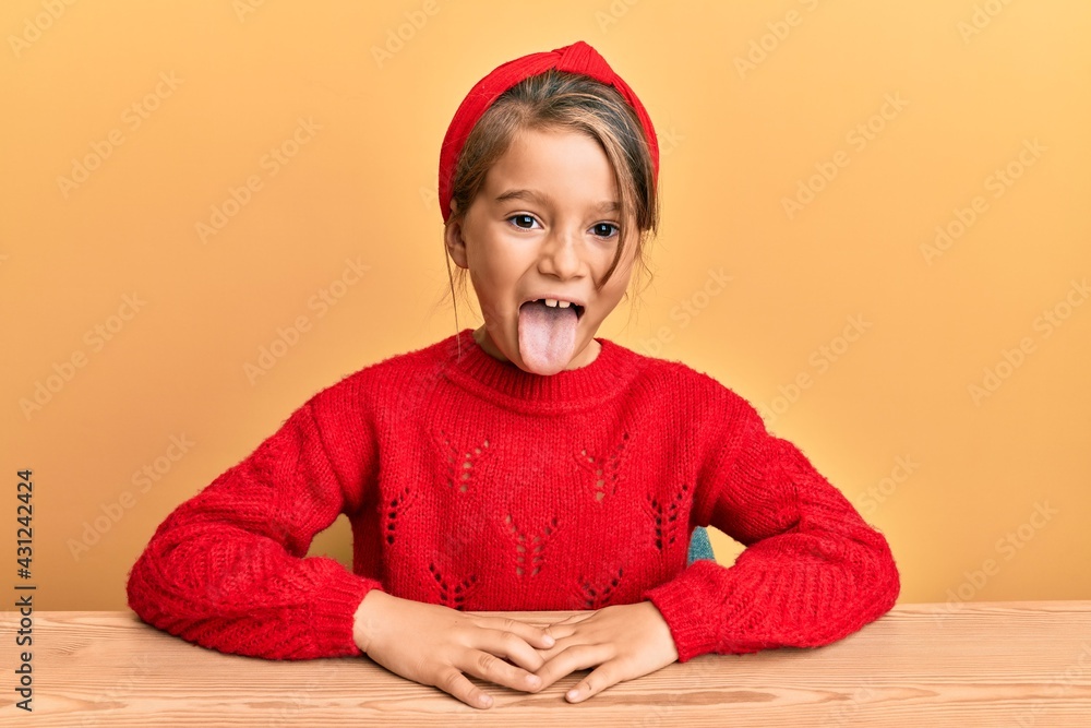 Ταπετσαρία Little beautiful girl wearing casual clothes sitting on the table sticking tongue out happy with funny expression