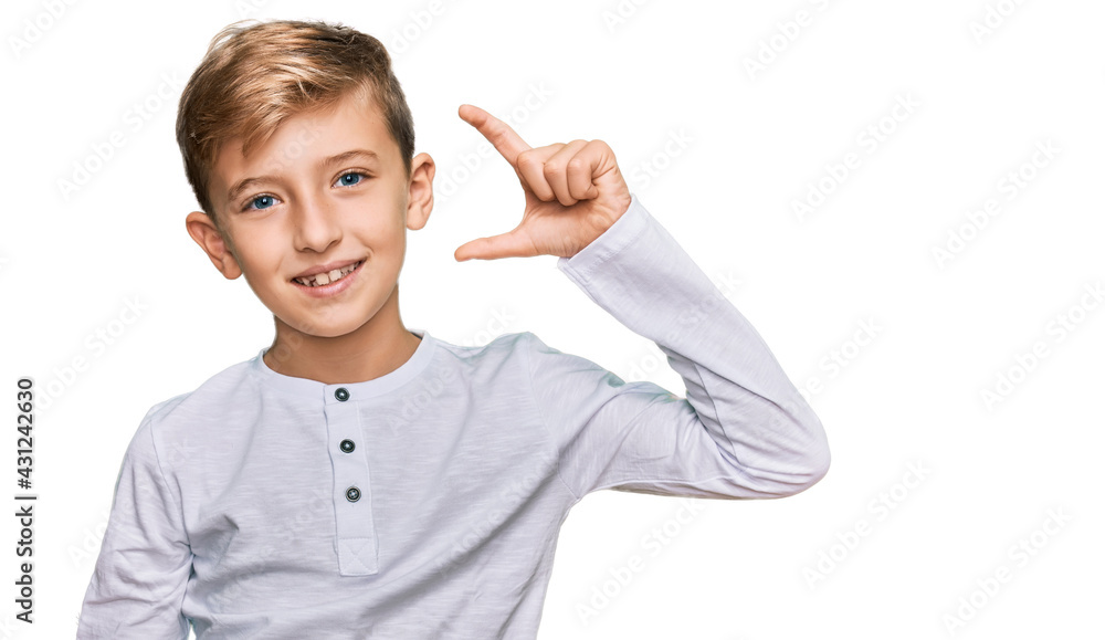 Little caucasian boy kid wearing casual clothes smiling and confident gesturing with hand doing small size sign with fingers looking and the camera. measure concept. Little caucasian boy kid wearing casual clothes smiling and confident gesturing with hand doing small size sign with fingers looking and the camera. measure concept.