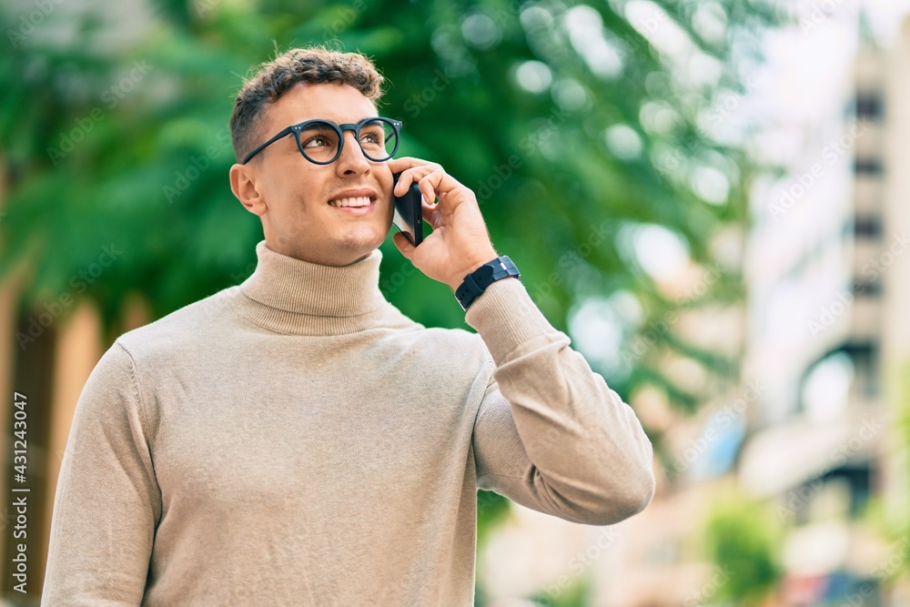 Young hispanic man wearing glasses talking on smartphone at the city. Young hispanic man wearing glasses talking on smartphone at the city.
