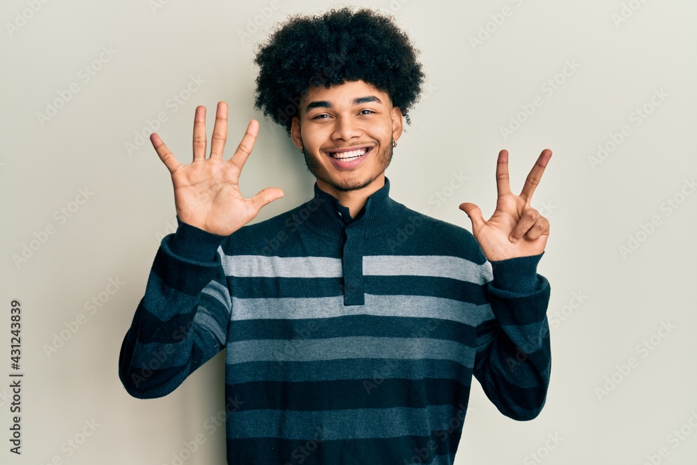 Young african american man with afro hair wearing casual clothes showing and pointing up with fingers number eight while smiling confident and happy. Young african american man with afro hair wearing casual clothes showing and pointing up with fingers number eight while smiling confident and happy.