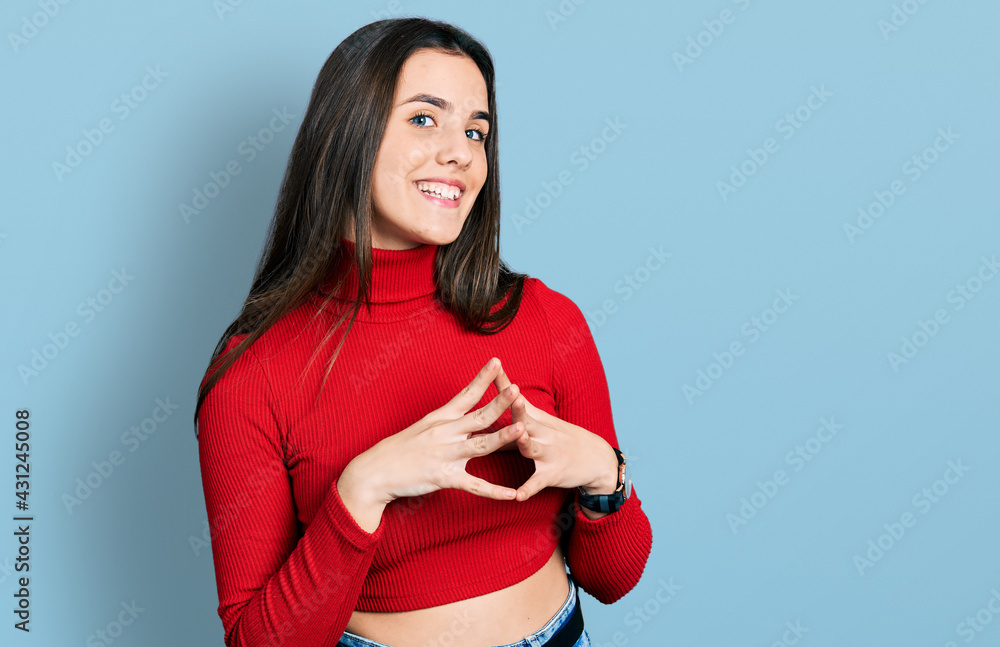 Young brunette teenager wearing red turtleneck sweater hands together and fingers crossed smiling relaxed and cheerful. success and optimistic Young brunette teenager wearing red turtleneck sweater hands together and fingers crossed smiling relaxed and cheerful. success and optimistic