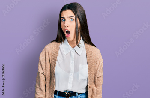 Young brunette teenager wearing casual white shirt and jacket scared and amazed with open mouth for surprise, disbelief face
