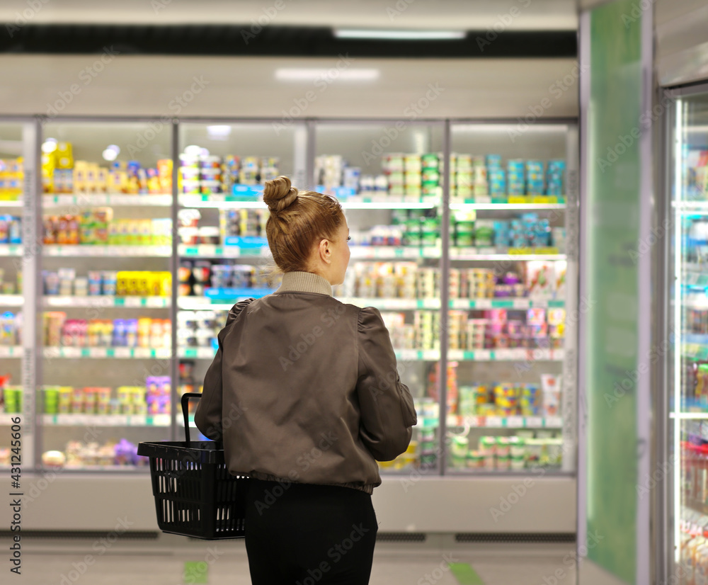Woman choosing frozen food from a supermarket freezer Woman choosing frozen food from a supermarket freezer
