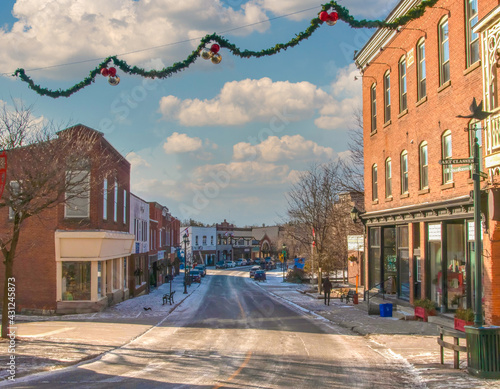 Quiet Main Street in small town in late afternoon winter, snow on ground, Christmas decorations overhead photo