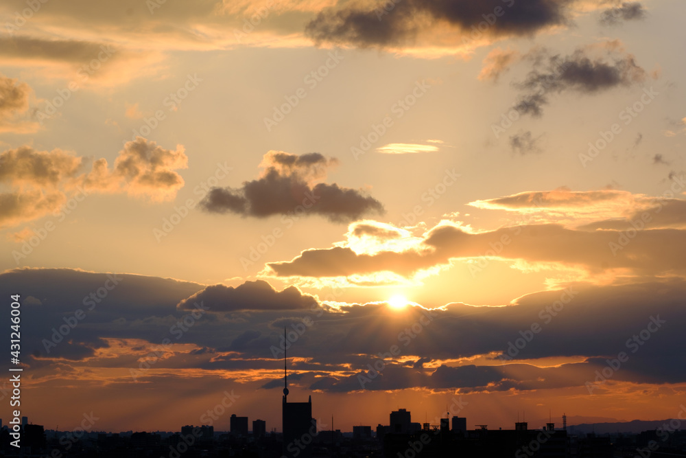 兵庫県神戸市東灘区の高層マンションの上層階からの夜明け。大阪生駒山から太陽が昇り、あたりはオレンジ色に染まり、ビル群がシルエットで浮かぶ。