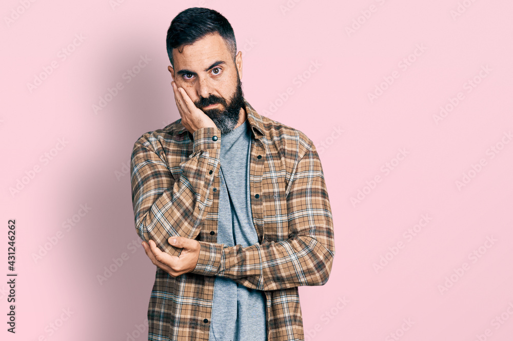 Hispanic man with beard wearing casual shirt thinking looking tired and bored with depression problems with crossed arms. Hispanic man with beard wearing casual shirt thinking looking tired and bored with depression problems with crossed arms.