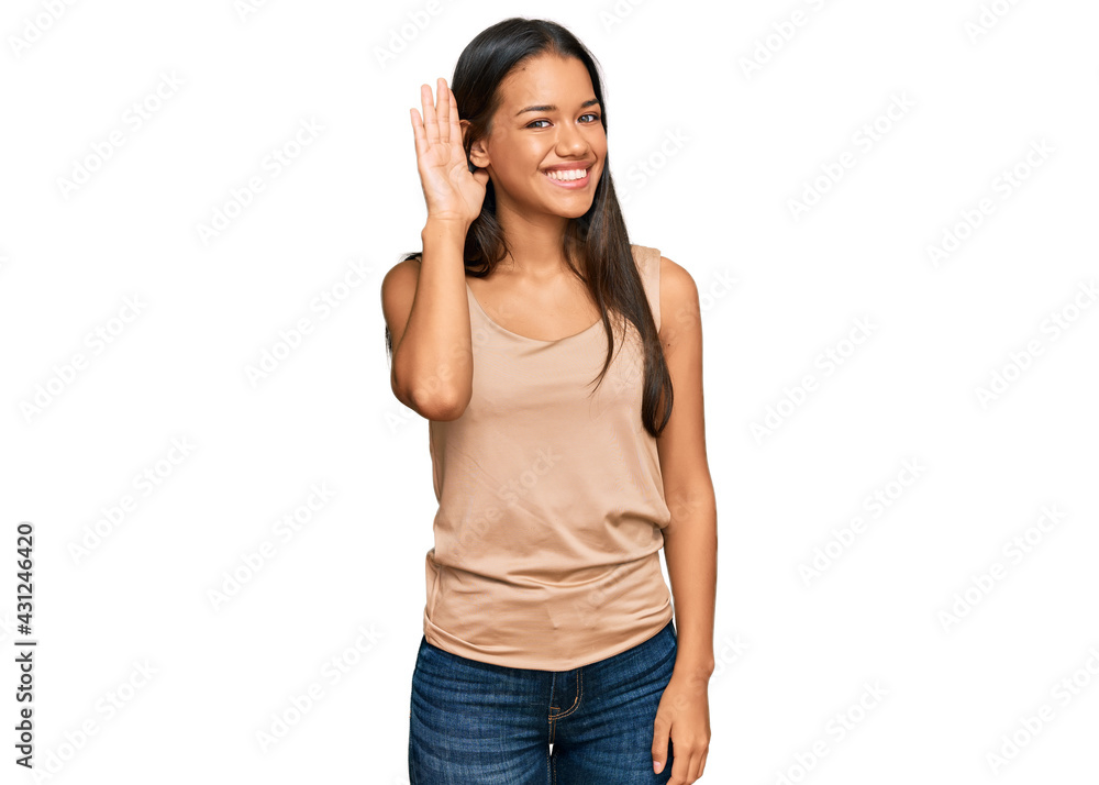Beautiful hispanic woman wearing casual clothes smiling with hand over ear listening an hearing to rumor or gossip. deafness concept. Beautiful hispanic woman wearing casual clothes smiling with hand over ear listening an hearing to rumor or gossip. deafness concept.