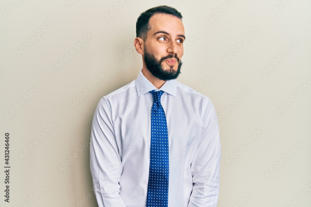 Young man with beard wearing business tie smiling looking to the side and staring away thinking. Young man with beard wearing business tie smiling looking to the side and staring away thinking.
