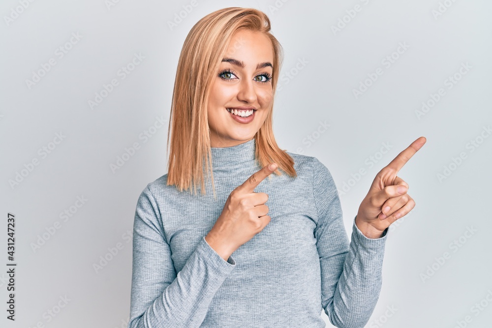 Beautiful caucasian woman wearing casual clothes smiling and looking at the camera pointing with two hands and fingers to the side. Beautiful caucasian woman wearing casual clothes smiling and looking at the camera pointing with two hands and fingers to the side.