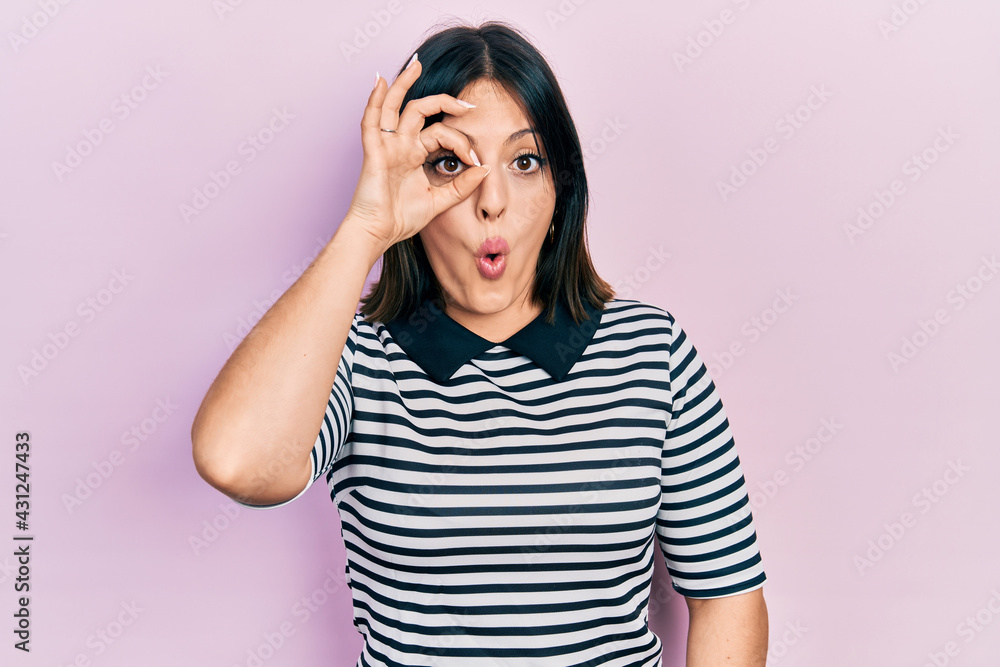 Young hispanic woman wearing casual clothes doing ok gesture shocked with surprised face, eye looking through fingers. unbelieving expression. Young hispanic woman wearing casual clothes doing ok gesture shocked with surprised face, eye looking through fingers. unbelieving expression.