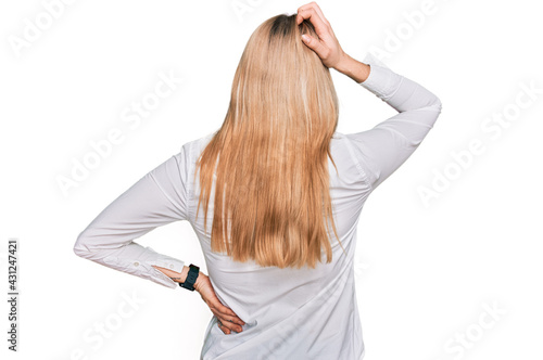 Young caucasian woman wearing casual clothes backwards thinking about doubt with hand on head