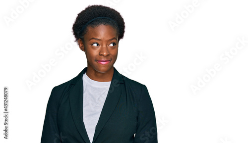 Young african american girl wearing business clothes smiling looking to the side and staring away thinking.