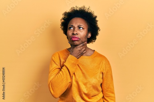 Young african american woman wearing casual clothes touching painful neck, sore throat for flu, clod and infection © Krakenimages.com