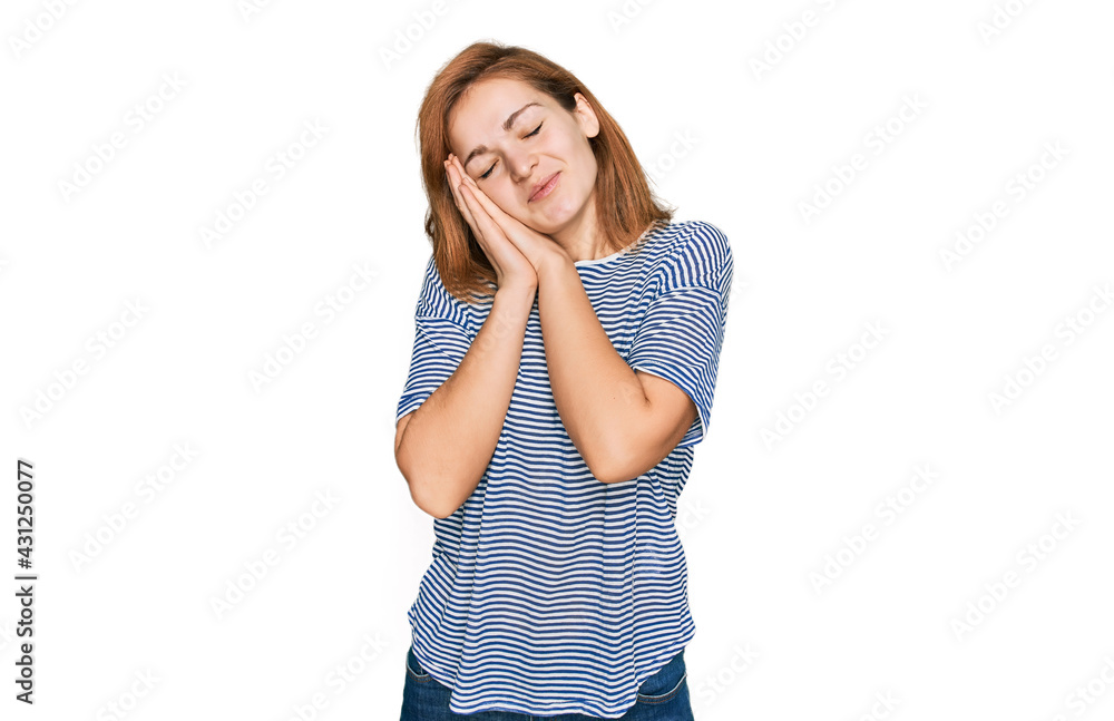 Young caucasian woman wearing casual clothes sleeping tired dreaming and posing with hands together while smiling with closed eyes. Young caucasian woman wearing casual clothes sleeping tired dreaming and posing with hands together while smiling with closed eyes.