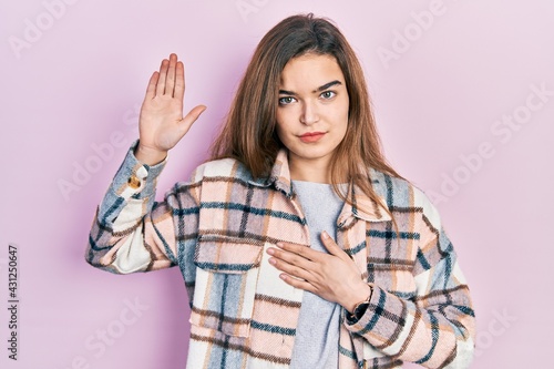 Young caucasian girl wearing casual clothes swearing with hand on chest and open palm, making a loyalty promise oath