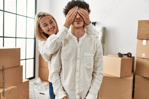 Girl surprising his boyfriend covering eyes at new home. © Krakenimages.com