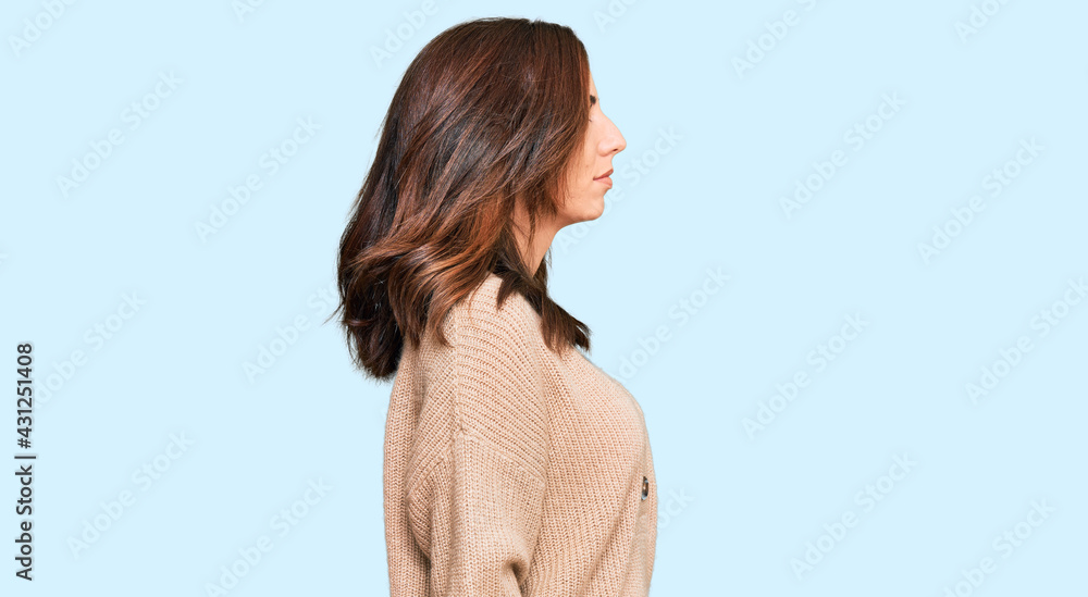 Young brunette woman wearing casual winter sweater looking to side, relax profile pose with natural face with confident smile. Young brunette woman wearing casual winter sweater looking to side, relax profile pose with natural face with confident smile.