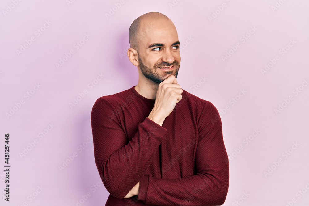 Young bald man wearing casual clothes with hand on chin thinking about question, pensive expression. smiling with thoughtful face. doubt concept. Young bald man wearing casual clothes with hand on chin thinking about question, pensive expression. smiling with thoughtful face. doubt concept.
